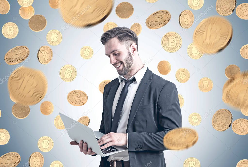 Bearded businessman with laptop, coins