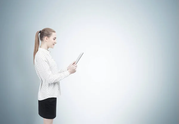 Blond woman with a tablet, side view — Stock Photo, Image