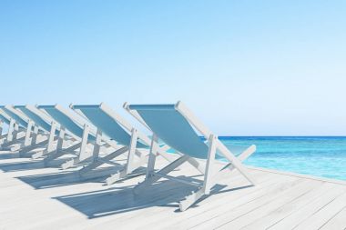 Mavi şezlonglar bir sıra ile ahşap iskele