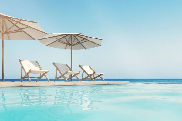 Swimming pool, deck chairs, umbrellas, horizon