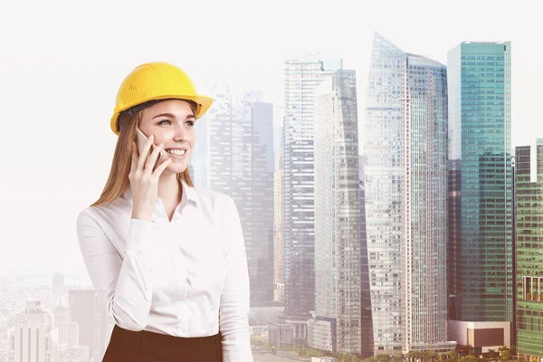 Mujer rubia en un hardhat en una ciudad — Foto de Stock