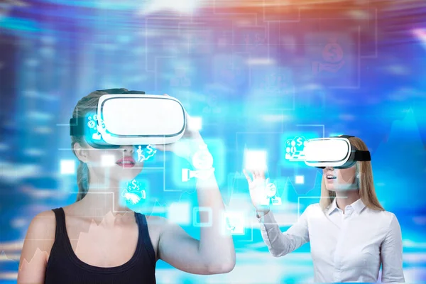 Women in VR glasses, economy icons, holograms