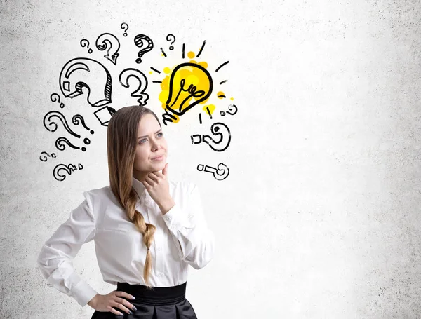 Pensive young woman, question marks and bulb — Stock Photo, Image