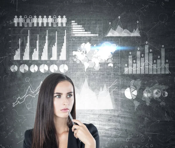 Bir kalem, grafikler ve bir harita dalgın kadınla