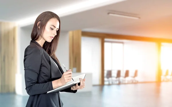 Vista laterale della donna con notebook in ufficio — Foto Stock