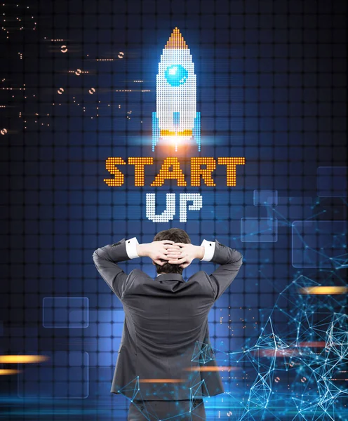 Businessman looking at a start up rocket — Stock Photo, Image
