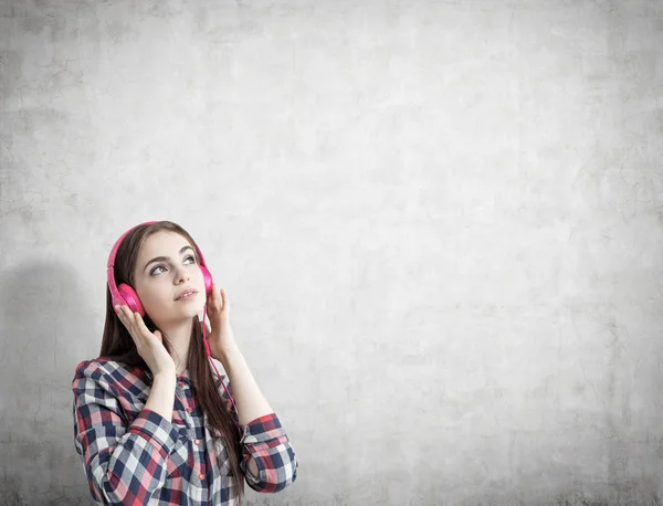 Adolescente avec écouteurs roses, béton — Photo