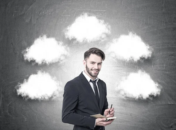 Hombre de negocios alegre con un planificador, nubes de pensamiento —  Fotos de Stock