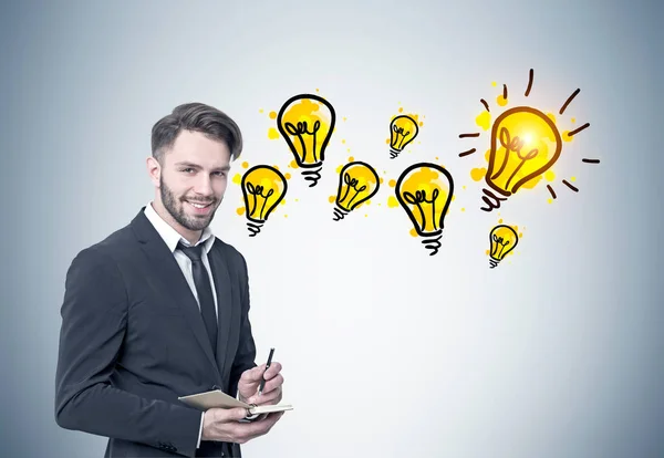 Smiling bearded businessman, many light bulbs — Stock Photo, Image