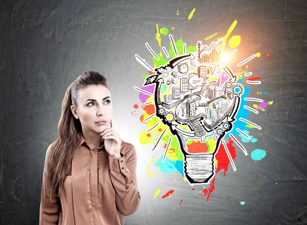 Pensive young businesswoman, light bulb scheme — Stock Photo, Image