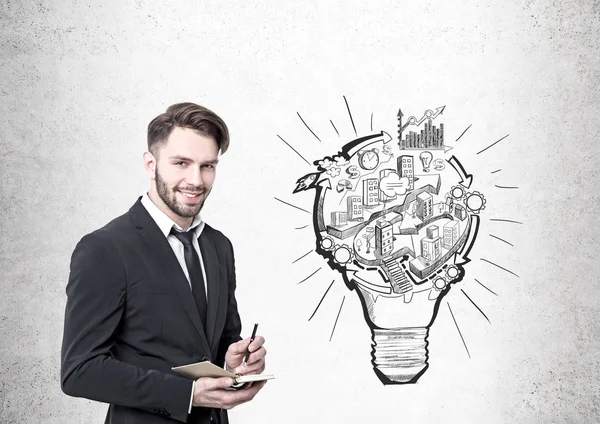 Businessman with a planner, a lightbulb scheme — Stock Photo, Image