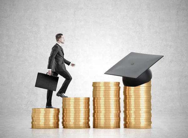 Stacks of coins and a graduation hat, businessman — Stock Photo, Image