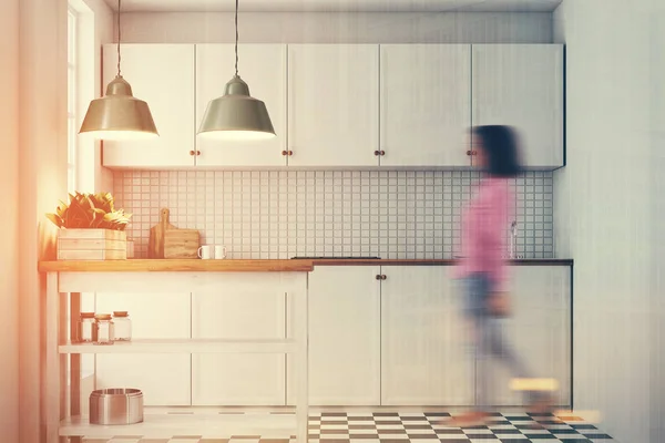 White kitchen interior, tiled floor, woman