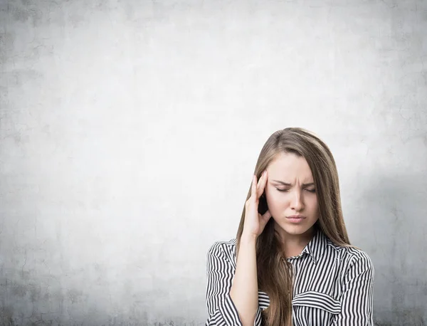 Stressed businesswoman with a headache, concrete — Stock Photo, Image