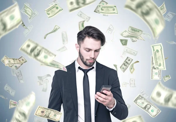 Бородатый бизнесмен смотрит на смартфон, долларовый дождь — стоковое фото