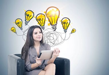 Kadın koltuk, bir tablet, parlak fikirler