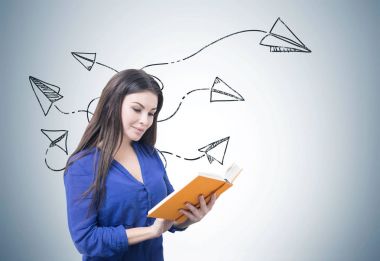 Kadın mavi kitap okumak kağıt uçaklar