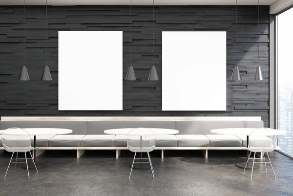 Schwarzes Café-Interieur, graue Sofas, zwei Poster — Stockfoto