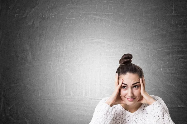 Stressad ung kvinna med en bulle, blackboard — Stockfoto