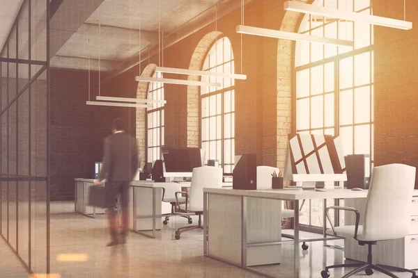 Brick office, arch windows, computers side, man