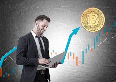 Gülümseyen genç işadamı, laptop, bitcoin grafiği