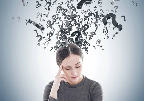 Stressed young woman in brown, question marks — Stock Photo, Image