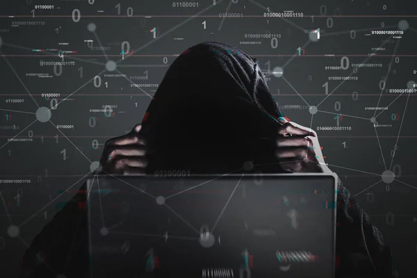 Hacker in una felpa nera con cappuccio, laptop, codice binario — Foto Stock