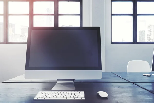 Tela de computador em branco em uma mesa de escritório preta — Fotografia de Stock