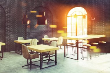 Siyah tuğla café köşesi, ahşap masa tonda