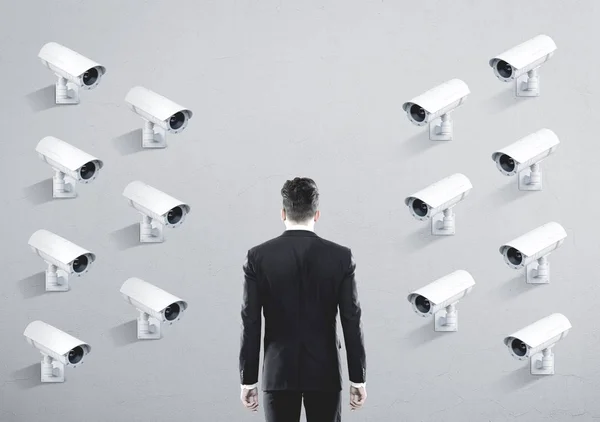 Muitas câmeras de CCTV em uma parede, homem de negócios — Fotografia de Stock