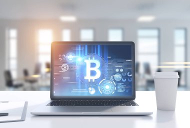 Dizüstü bilgisayar ile bir bitcoin sembol ofis, kahve Kupası