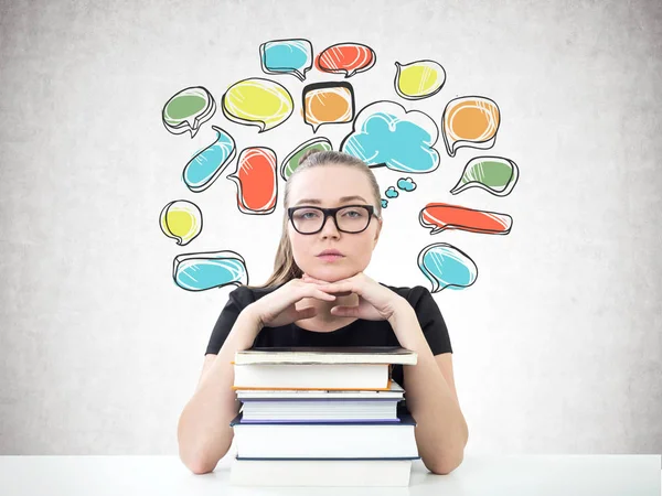 Serious blonde student, books, speech bubbles — Stock Photo, Image