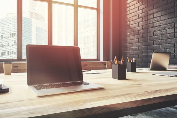 Ordinateur portable à écran vierge dans un bureau en brique noire — Photo