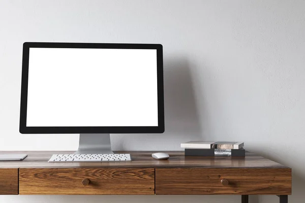 White computer screen on a dark wooden desk