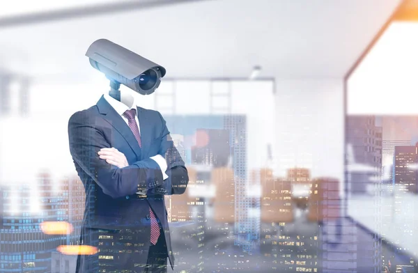 Porträt eines Geschäftsmannes im Anzug und mit verschränkten Armen. Sein Kopf ist eine Videokamera. ein verschwommener Konferenzraum-Hintergrund. getöntes Bild Doppelbelichtung Attrappe — Stockbild Mann mit Videokamera Kopf, Büro — Stockfoto