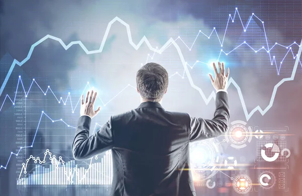 Businessman with hands in the air, graphs — Stock Photo, Image