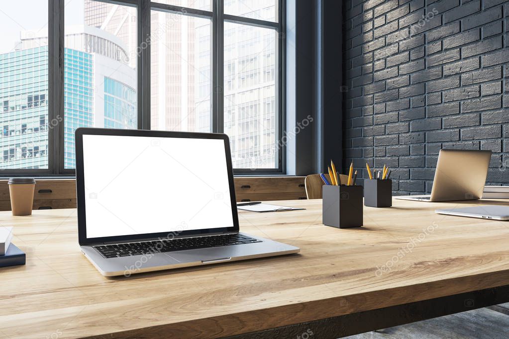 White screen laptop in a black brick office