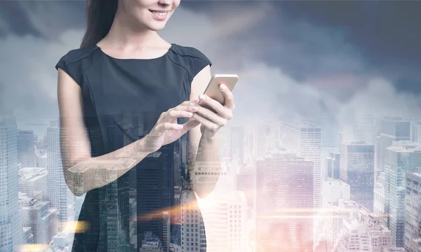 Affärskvinna med en smartphone, dimmigt city — Stockfoto