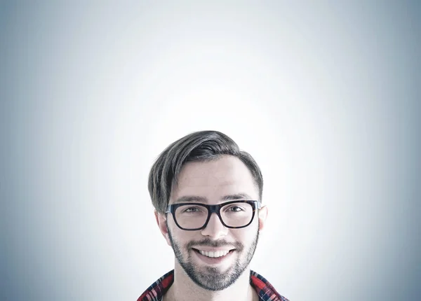 Sorrindo hipster cara em óculos, fundo cinza — Fotografia de Stock