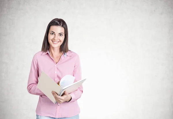 Mujer joven sonriente, copybook, hormigón —  Fotos de Stock