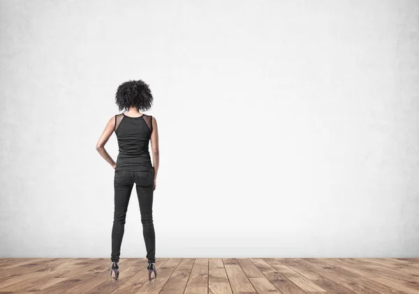 African American woman in empty room, rear view — Stock Photo, Image