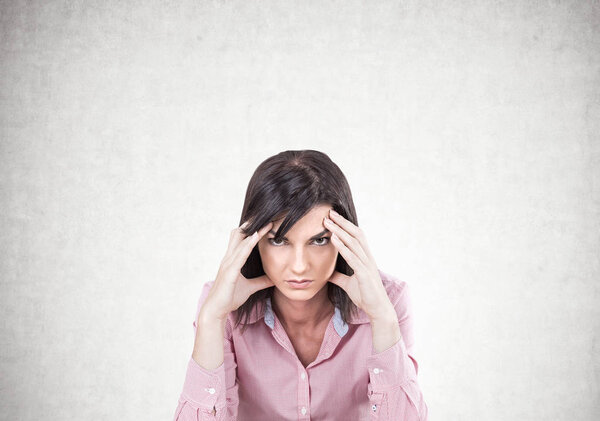 Stressed young brunette sitting, concrete