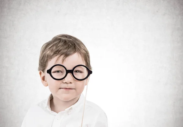Roztomilý malý chlapec s brýlemi, beton — Stock fotografie