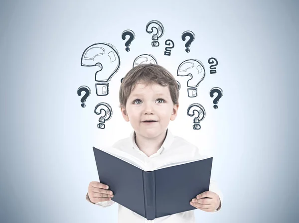 Söt liten pojke med en bok, frågetecken — Stockfoto