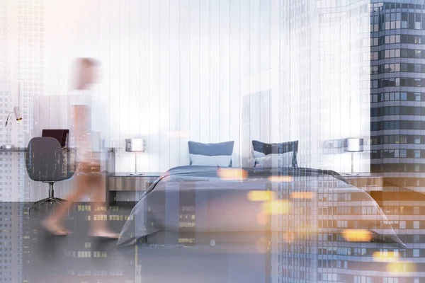 Woman in a white bedroom with a computer desk — Stock Photo, Image