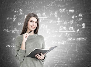 Gülümseyen kadın bir planlayıcısı ile Fizik formülü