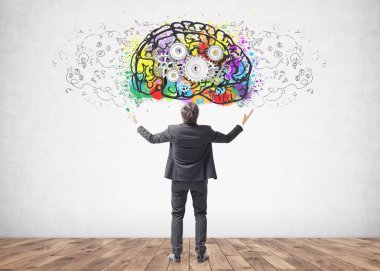 Arkadan görünüş genç başarılı işadamı ile ayakta eller havaya bir iş zaferini kutluyor. Beton duvar arka plan üzerine bir cog beyin kroki ile.