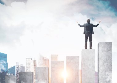 Arkadan görünüş genç başarılı işadamı ile eller havaya bir iş zaferini kutluyor. Bir büyük şehir gökyüzüne bakarak bir çubuk grafik üzerinde duruyor. Resim sahte tonda