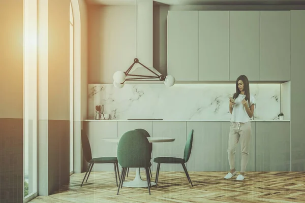 Mulher em uma sala de jantar cadeiras verdes e cozinha — Fotografia de Stock