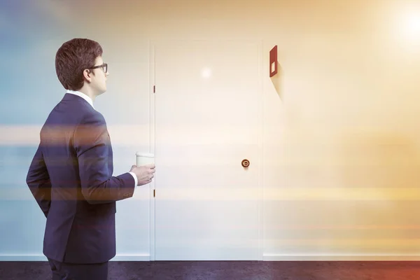Zakenman in de buurt van gesloten deur op een witte muur kamer — Stockfoto